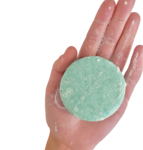 Une barre de shampoing bleu dans la main d'une personne