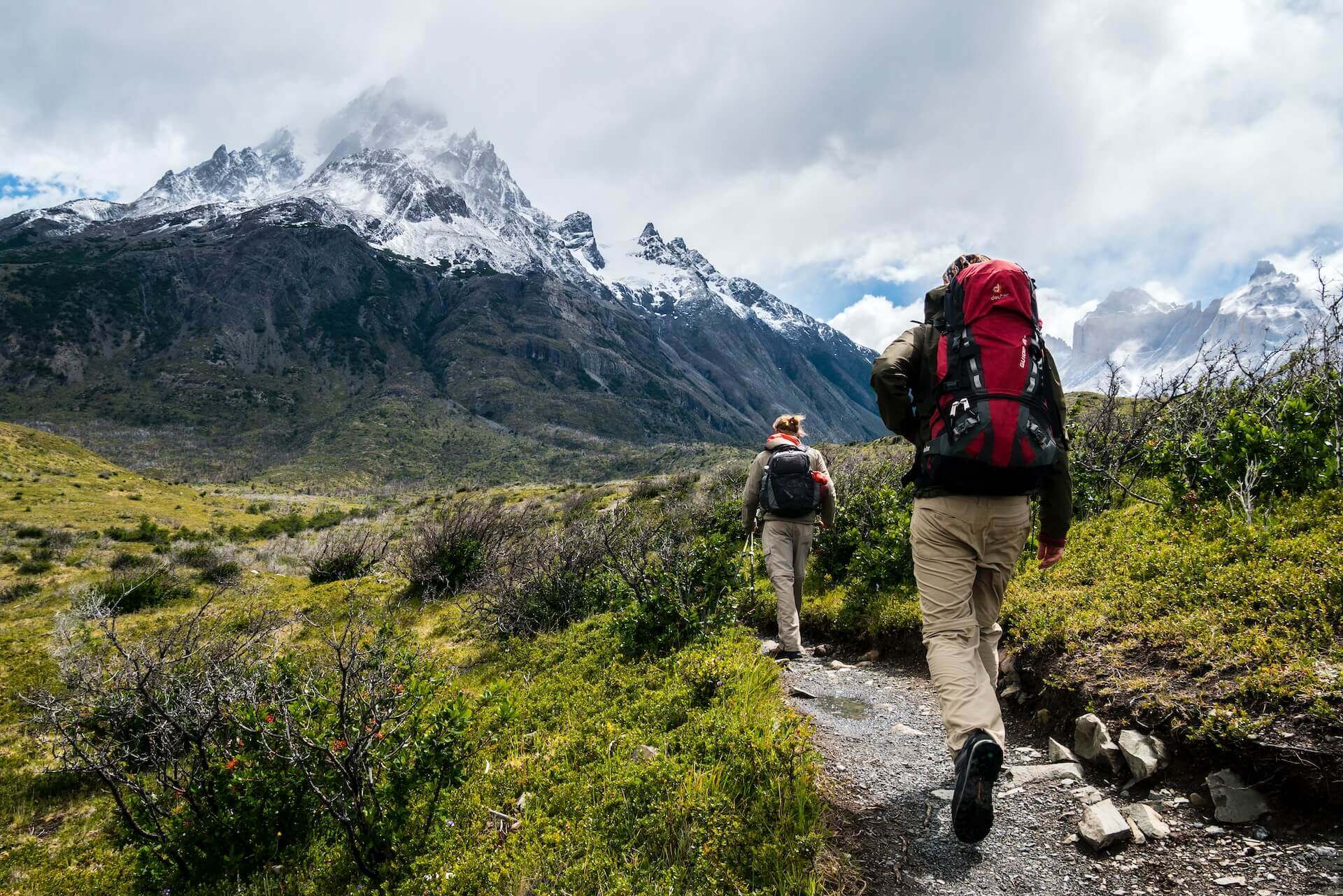 Two people are hiking with a view on a snowy mountain.